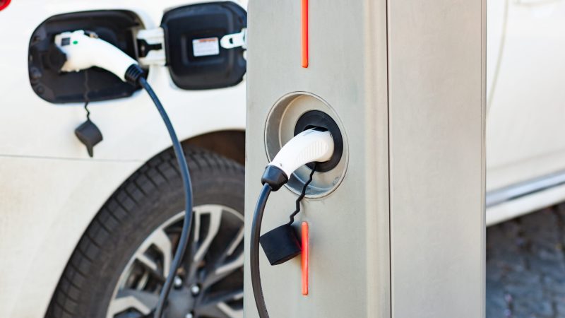 The electric car charger plugged in to the socket.The modern electric car charging the battery.